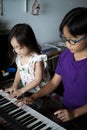 Asian children young kids playing keyboard piano at home Royalty Free Stock Photo