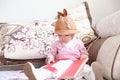 Asian Chinese Baby girl With a hat reading book on sofa