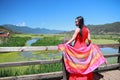 Asian Chinese beauty in red dress enjoy peaceful and happy life at Yunnan Lugu walking marriage bridge