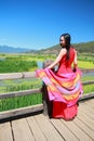 Asian Chinese beauty in red dress enjoy peaceful and happy life at Yunnan Lugu walking marriage bridge