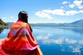 Asian Chinese beauty in red dress with red scraf on head, at Yunnan Lugu lake, enjoy free time