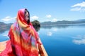 Asian Chinese beauty in red dress with red scraf on head, at Yunnan Lugu lake, enjoy free time