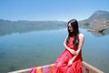 Asian Chinese beauty in red dress at Yunnan Lugu lake, enjoy free time