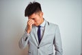 Asian chinese businessman wearing suit and tie standing over isolated yellow background tired rubbing nose and eyes feeling Royalty Free Stock Photo