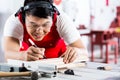 Asian Chinese Carpenter cutting wood with saw Royalty Free Stock Photo