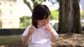 Asian chinese single child girl eating ice cream hungrily for the first time