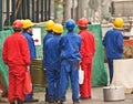 Asian construction workers dressed colorful workswear stand In waiting on street with a large dining pots