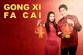 Asian Chinese couple in cheongsam dress holding Chinese lantern and Gong Xi Fa Cai text Royalty Free Stock Photo