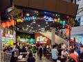 Asian Chinese diners having a meal and socialising at a Malaysia Chiak! food court in Singapore, Southeast Asia. The Chinese words