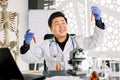 Asian Chinese doctor virologist scientist working in lab making medical research, using microscope, test tubes Royalty Free Stock Photo