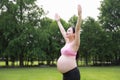 Asian Eastern Chinese happy beautiful pregnant woman hug embrace nature in green forest outdoor sunshine sunset sunrise day hope