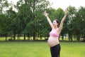 Asian Eastern Chinese happy beautiful pregnant woman hug embrace nature in green forest outdoor relaxed peaceful life Royalty Free Stock Photo