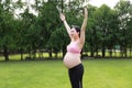 Asian Eastern Chinese happy beautiful pregnant woman hug embrace nature in green forest outdoor relaxed peaceful life Royalty Free Stock Photo