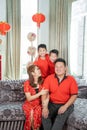 Asian chinese family with two son holding ang pao smiling when sitting on sofa Royalty Free Stock Photo