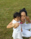 Asian chinese female parent blowing bubbles with baby girl