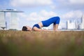 Asian Chinese Female Yogi outdoor yoga bridge exercise under the sun