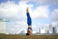 Asian Chinese Female Yogi outdoor head stand yoga exercise under the sun