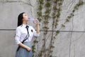 Relax Asian Chinese pretty girls wear student suit in school enjoy free time drink water in nature spring garden Royalty Free Stock Photo