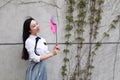 Relax Asian Chinese pretty girls wear student suit in school enjoy free time play windmill in nature spring garden Royalty Free Stock Photo