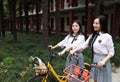 Relax Asian Chinese pretty girls wear student suit in school enjoy free time ride bike in nature spring garden