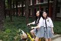 Relax Asian Chinese pretty girls wear student suit in school enjoy free time ride bike in nature spring garden