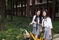 Relax Asian Chinese pretty girls wear student suit in school enjoy free time ride bike in nature spring garden Royalty Free Stock Photo