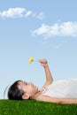 Asian Chinese girl lying on the grass and holding flower Royalty Free Stock Photo