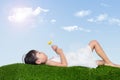 Asian Chinese girl lying on the grass and holding flower Royalty Free Stock Photo