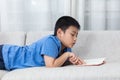 Asian Chinese little boy reading book on the sofa Royalty Free Stock Photo