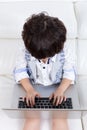 Asian Chinese little boy sitting on the couch with laptop Royalty Free Stock Photo