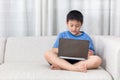Asian Chinese little boy using laptop on the sofa Royalty Free Stock Photo