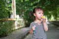 Happy little cute lovely girl Chinese child smile laugh blow balloon have fun at summer park nature happiness childhood Royalty Free Stock Photo