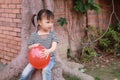 Happy little cute lovely girl Chinese child smile laugh play red balloon have fun at summer park nature happiness childhood Royalty Free Stock Photo