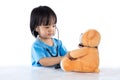 Asian Chinese little doctor girl examine teddy bear Royalty Free Stock Photo