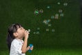 Asian Chinese little girl blowing soap bubbles Royalty Free Stock Photo