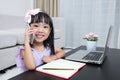 Asian Chinese little girl busy reading mobile phone and laptop