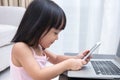 Asian Chinese little girl busy reading mobile phone and laptop