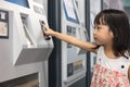Asian Chinese little girl buying admission ticket at MRT station