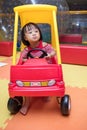 Asian Chinese little girl driving toy car at playground Royalty Free Stock Photo