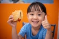 Asian Chinese little girl eating burger Royalty Free Stock Photo