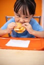 Asian Chinese little girl eating burger Royalty Free Stock Photo