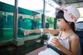 Asian Chinese little girl eating ice cream and watching fishes Royalty Free Stock Photo