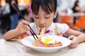 Asian Chinese little girl eating noodles with chopsticks Royalty Free Stock Photo