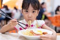 Asian Chinese little girl eating noodles with chopsticks Royalty Free Stock Photo