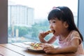 Asian Chinese little girl eating pizza pepperoni