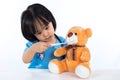 Asian Chinese little girl examine teddy bear with thermometer Royalty Free Stock Photo