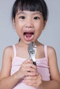 Asian Chinese little girl holding pliers and showing the gap