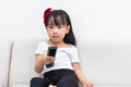 Asian Chinese little girl holding a TV remote control Royalty Free Stock Photo