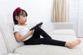 Asian Chinese little girl holding a TV remote control Royalty Free Stock Photo