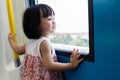 Asian Chinese little girl inside train looking beside the window Royalty Free Stock Photo